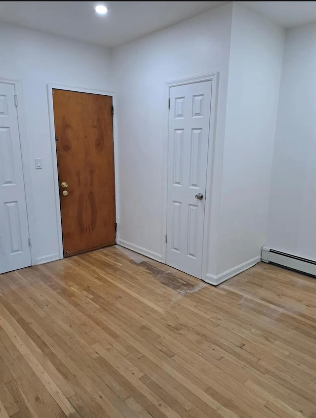 unfurnished room with light hardwood / wood-style floors and baseboard heating