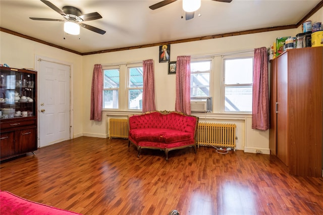 sitting room with hardwood / wood-style flooring, ornamental molding, and radiator