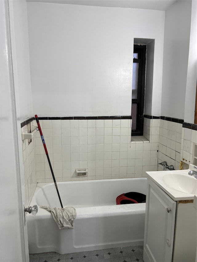 bathroom featuring vanity, a bathtub, and tile walls