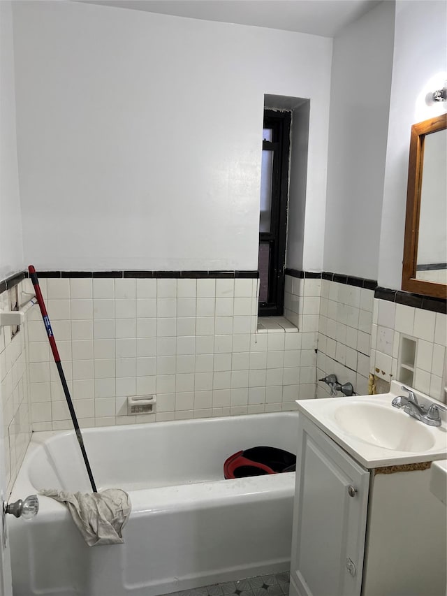 bathroom featuring vanity, a bathtub, and tile walls