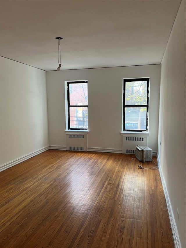 unfurnished room featuring dark hardwood / wood-style floors and radiator