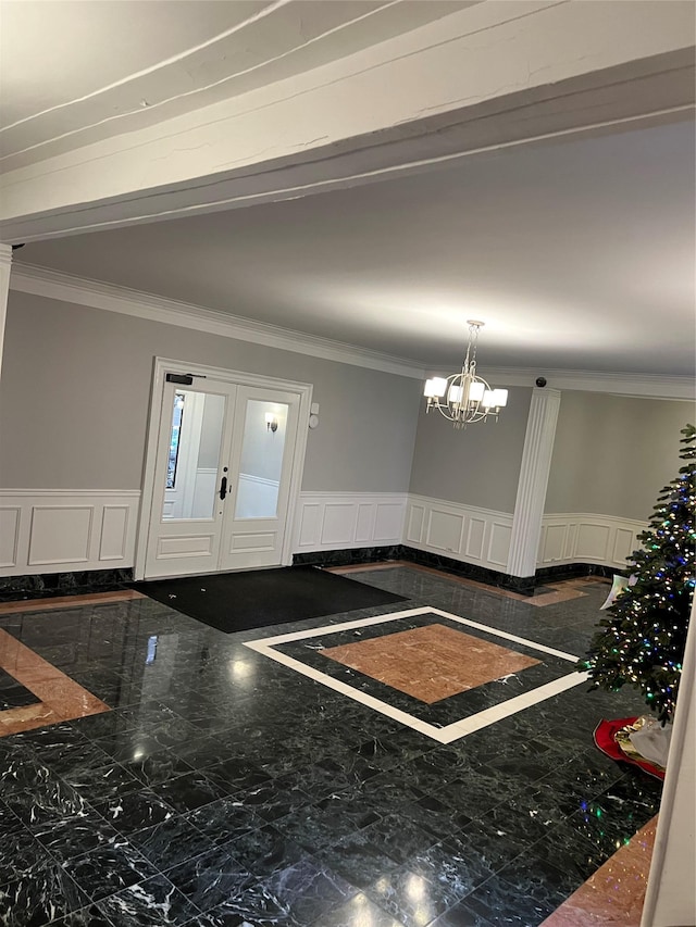 entryway featuring a notable chandelier and ornamental molding