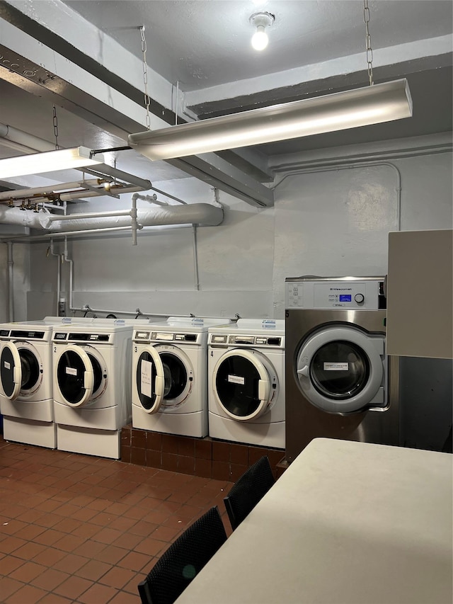 laundry area featuring dark tile patterned flooring and washer and clothes dryer