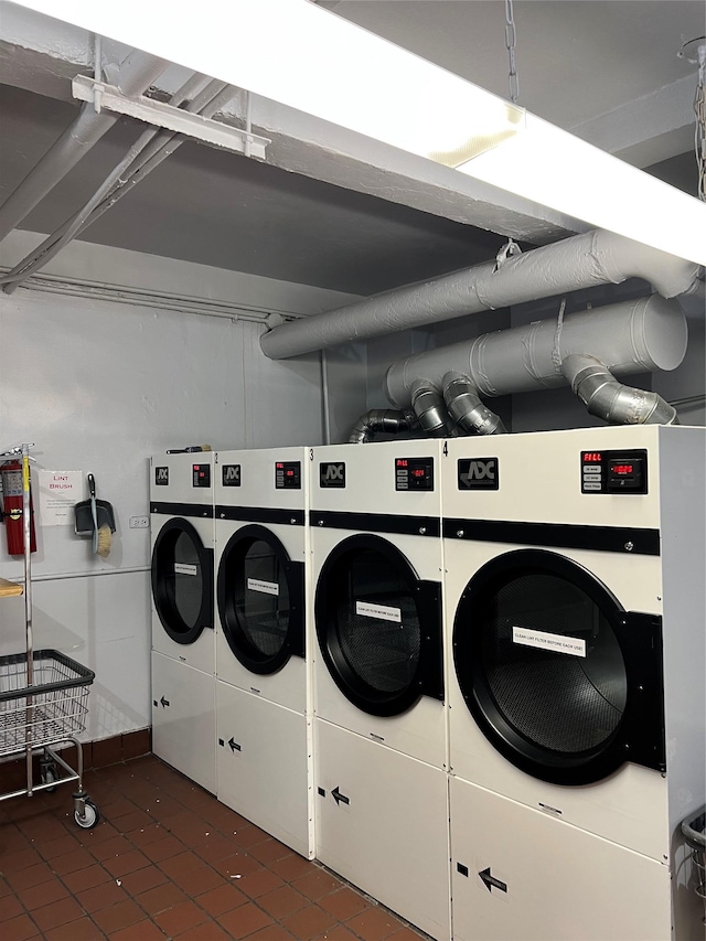 laundry area featuring dark tile patterned flooring and washing machine and clothes dryer