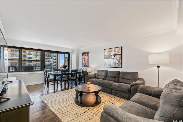 living room featuring dark wood-type flooring and crown molding