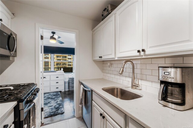 kitchen featuring light wood-type flooring, white cabinetry, sink, and appliances with stainless steel finishes