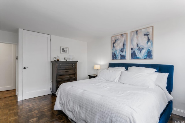 bedroom featuring dark parquet flooring