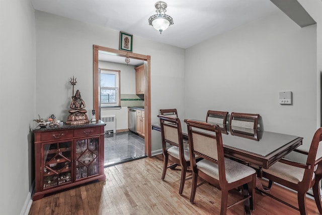 dining area featuring radiator heating unit and light hardwood / wood-style flooring