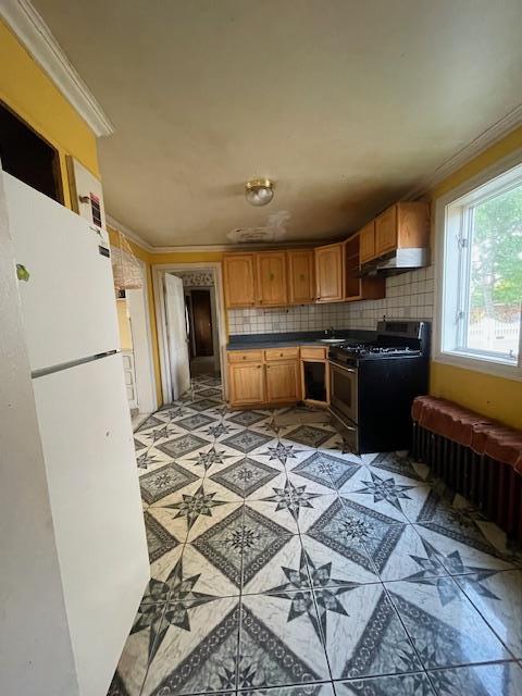 817 Southard St, Baldwin, NY 11510 - kitchen featuring stainless steel gas stove, ornamental molding, freestanding refrigerator, decorative backsplash, and dark countertops