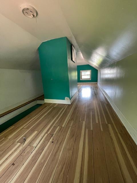 817 Southard St, Baldwin, NY 11510 - bonus room with hardwood / wood-style floors, vaulted ceiling, and baseboards