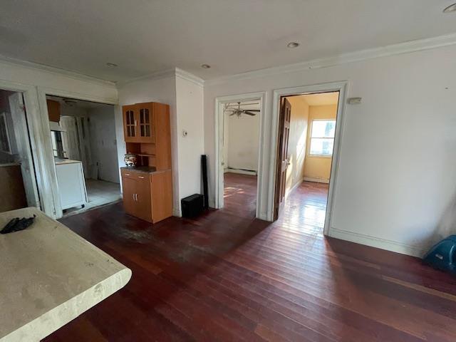 817 Southard St, Baldwin, NY 11510 - unfurnished living room featuring crown molding, dark wood-style flooring, washer / clothes dryer, and baseboards