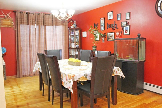 dining space with a notable chandelier, light wood-type flooring, and a baseboard radiator