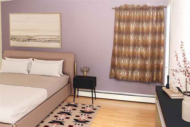 bedroom with wood-type flooring and a baseboard radiator