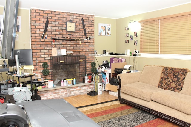 living room with hardwood / wood-style flooring and a brick fireplace