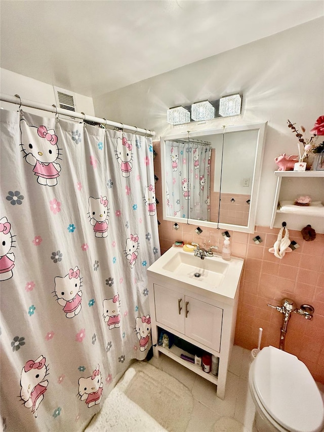 bathroom with vanity, toilet, tile walls, and curtained shower