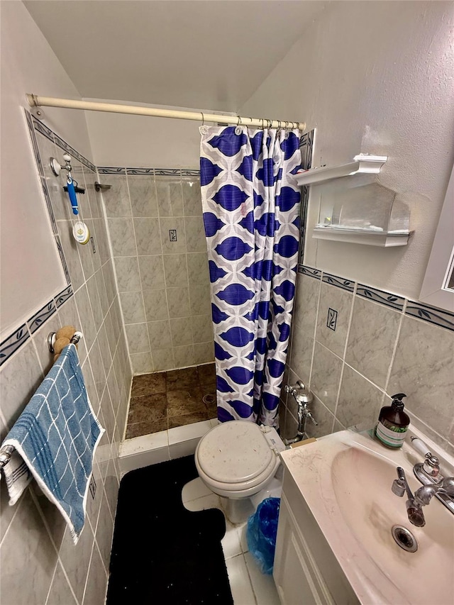 bathroom featuring tile patterned flooring, vanity, tile walls, and walk in shower