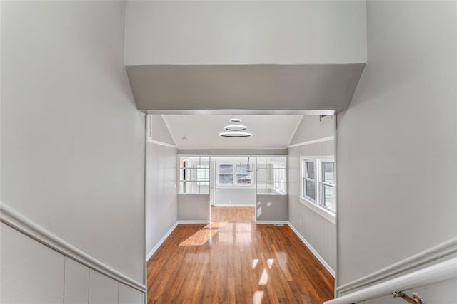 hall featuring hardwood / wood-style floors and vaulted ceiling