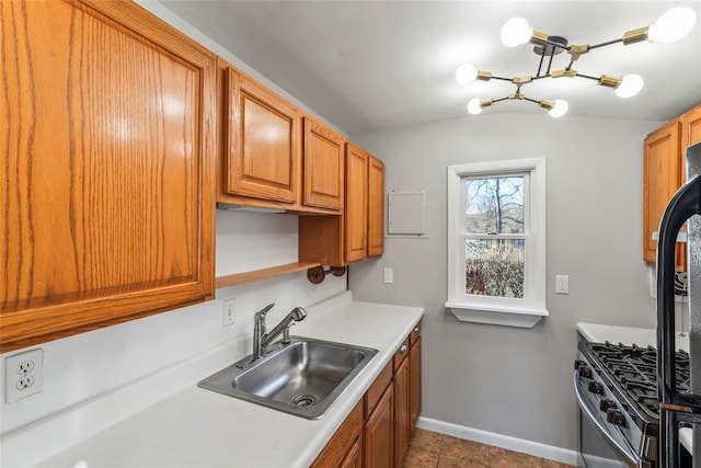 kitchen featuring stainless steel gas stove, light tile patterned floors, and sink