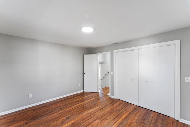 unfurnished bedroom featuring a closet and dark hardwood / wood-style floors