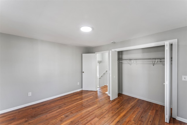 unfurnished bedroom featuring dark hardwood / wood-style flooring and a closet