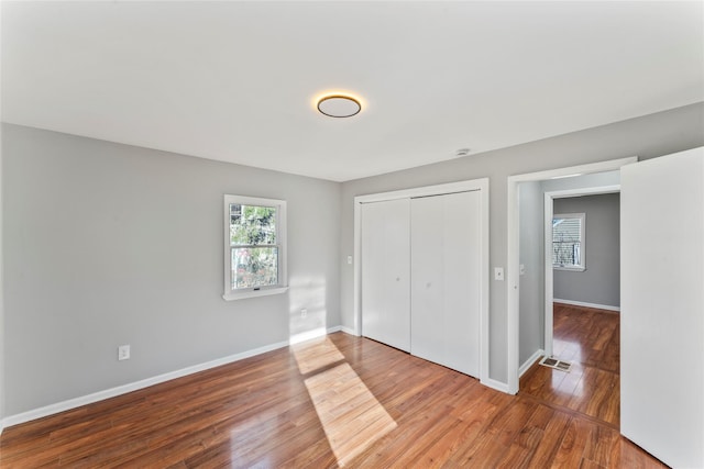 unfurnished bedroom with hardwood / wood-style floors and a closet