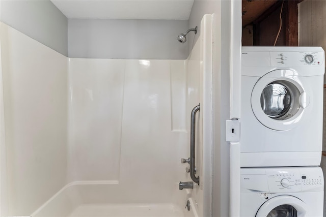 bathroom with stacked washer and clothes dryer and tub / shower combination