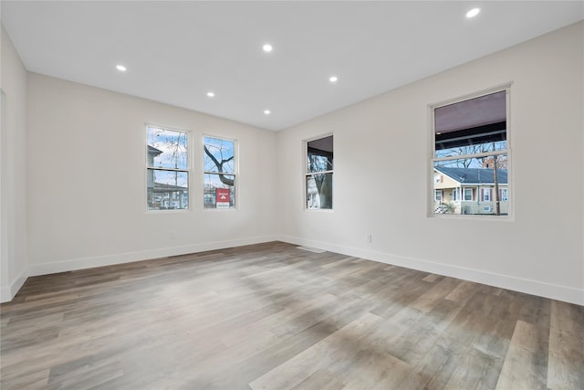 spare room with plenty of natural light and light hardwood / wood-style floors