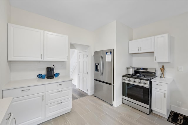 kitchen featuring white cabinets, stainless steel appliances, and light hardwood / wood-style floors