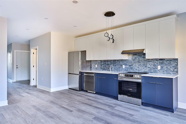 kitchen featuring hanging light fixtures, stainless steel appliances, blue cabinets, light hardwood / wood-style floors, and white cabinets