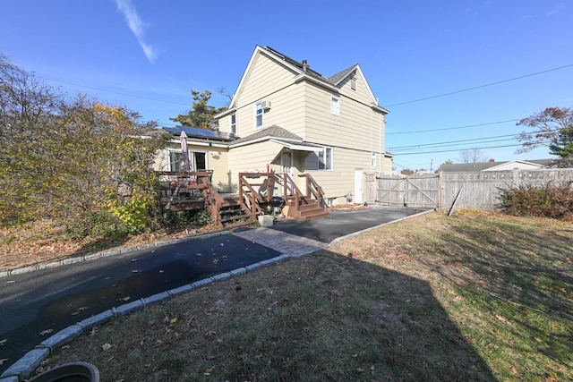 651 Madison Ave, Lindenhurst, NY 11757 - back of property featuring a gate, a deck, and solar panels
