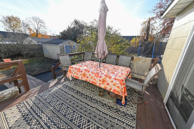 651 Madison Ave, Lindenhurst, NY 11757 - deck with a shed, a trampoline, outdoor dining area, and a fenced backyard