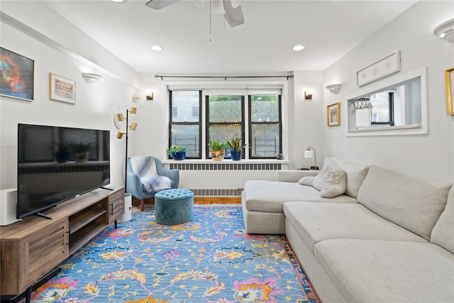 living room featuring hardwood / wood-style floors, radiator heating unit, and ceiling fan