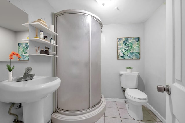 bathroom featuring tile patterned flooring, toilet, and a shower with shower door