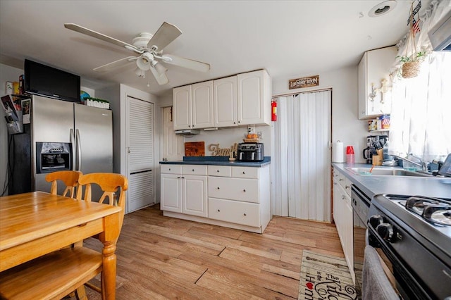 kitchen with sink, light hardwood / wood-style flooring, ceiling fan, stainless steel fridge, and white cabinetry