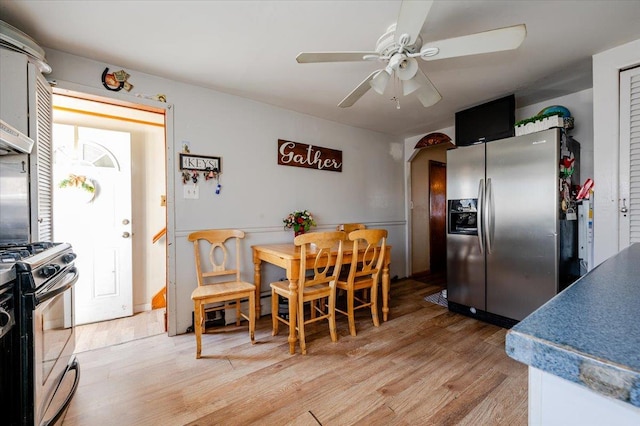 dining space with ceiling fan and light hardwood / wood-style flooring