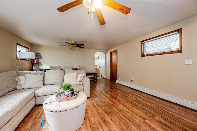 living room featuring hardwood / wood-style flooring, ceiling fan, and a baseboard heating unit