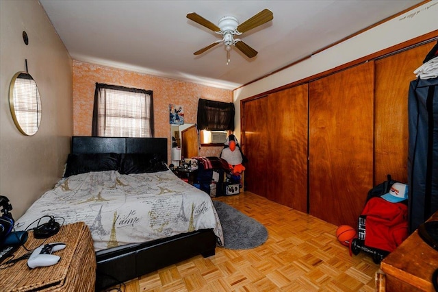 bedroom with ceiling fan, a closet, crown molding, and light parquet floors