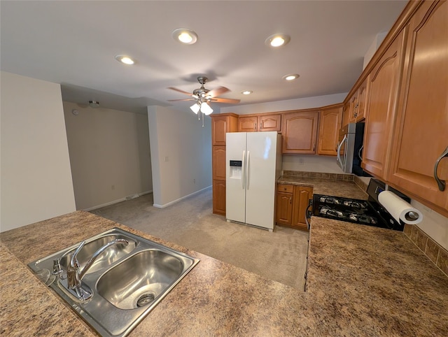 kitchen featuring light colored carpet, ceiling fan, sink, range, and white fridge with ice dispenser