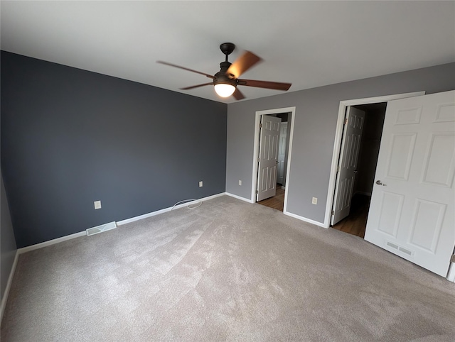 unfurnished bedroom with connected bathroom, ceiling fan, and dark carpet