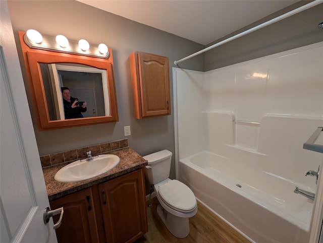 full bathroom with hardwood / wood-style floors, vanity, toilet, and shower / bath combination