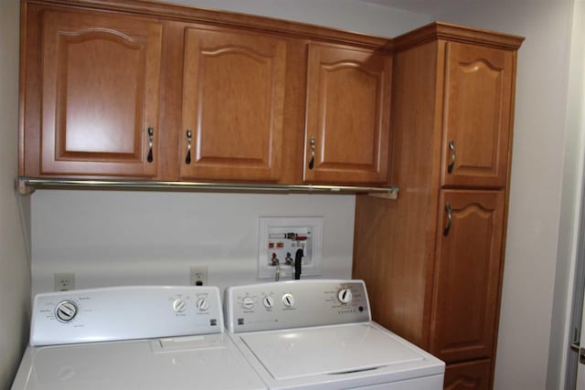 laundry area with washer and clothes dryer and cabinets