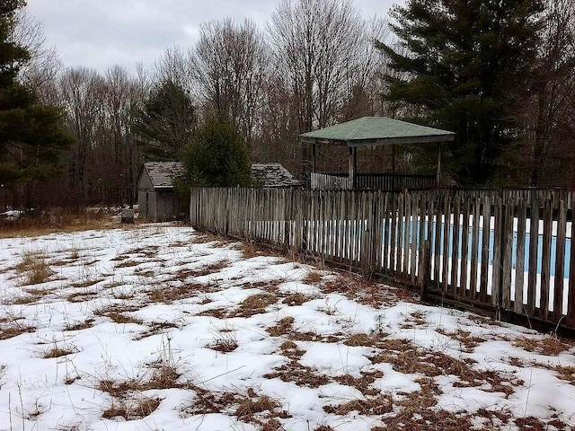 yard layered in snow with a covered pool