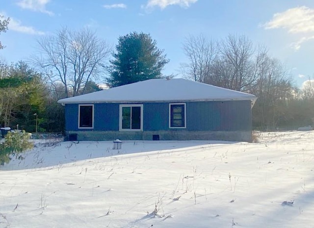 view of snow covered back of property