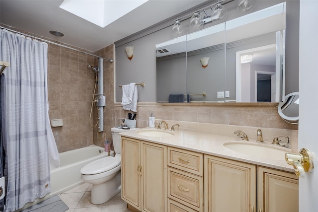 full bathroom with vanity, tile patterned floors, a skylight, toilet, and shower / bathtub combination with curtain