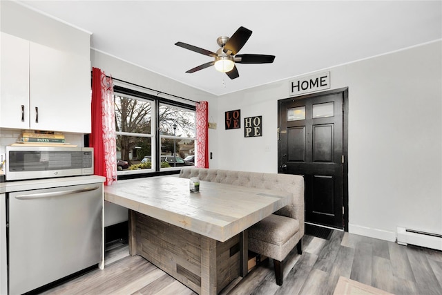 dining room featuring breakfast area, ceiling fan, light wood-type flooring, and baseboard heating