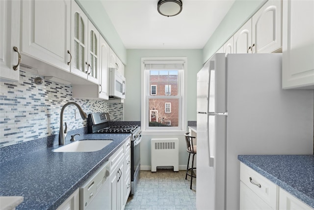 kitchen featuring white appliances, white cabinets, radiator heating unit, decorative backsplash, and sink