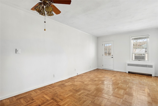 spare room featuring ceiling fan, light parquet floors, cooling unit, and radiator