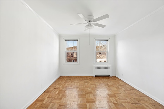 empty room with ceiling fan, light parquet flooring, radiator, and crown molding