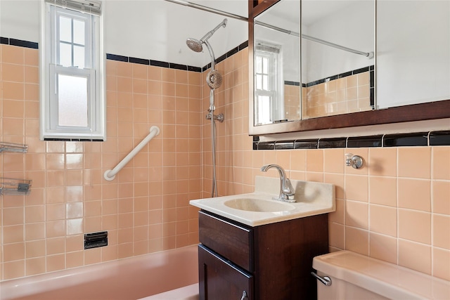 full bathroom with toilet, a healthy amount of sunlight, vanity, and tile walls