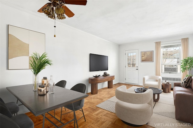 living room featuring ceiling fan, light parquet flooring, radiator heating unit, and crown molding